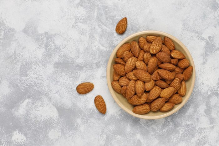 Fresh almonds in ceramic plates.top view