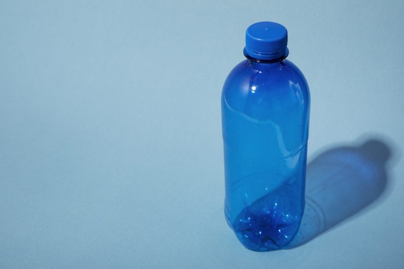 plastic-bottle-on-blue-background-high-angle