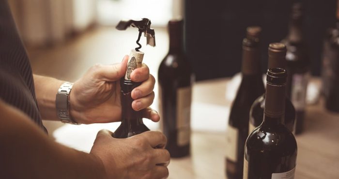 men-s-hands-open-bottle-wine-with-corkscrew