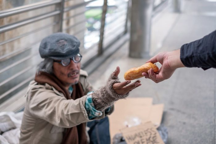 old-man-homeless-reach-out-get-bread-from-donor-corridor-bridge